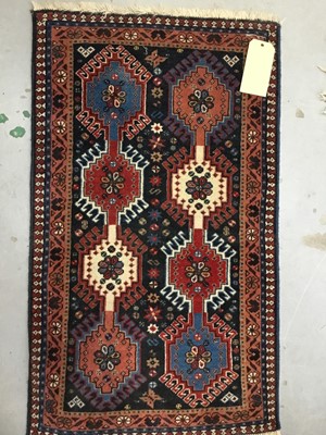 Lot 882 - Three rugs to include a Keshan rug with central medallion on red ground 180cm x 91cm, Persian rug 94cm x 55cm and a rug on pale red ground 205cm x 122cm