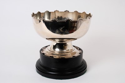 Lot 336 - Silver punch bowl with Monteith-style edge, engraved family crest and motto, on circular foot (Birmingham 1917), 23cm diameter, 25 troy ozs, on ebonised plinth