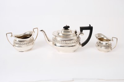 Lot 271 - George V silver three piece bachelor's tea set, comprising teapot of compressed baluster form, with angular ebony handle and hinged domed cover, matching sugar and milk jug, (Chester 1912)