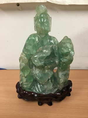 Lot 290 - Oriental carved hardstone sculpture of a seated figure and dog of Fo, on carved hardwood base, 24cm high
