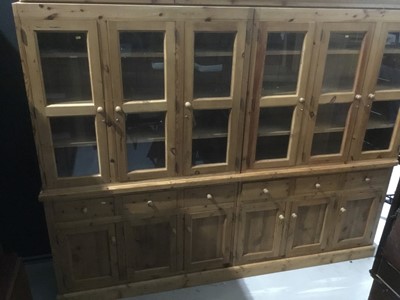 Lot 1129 - Large pine bookcase/dresser in four sections with glazed doors above, drawers and cupboards below