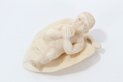 Lot 672 - Eastern ivory carving of a child on a leaf