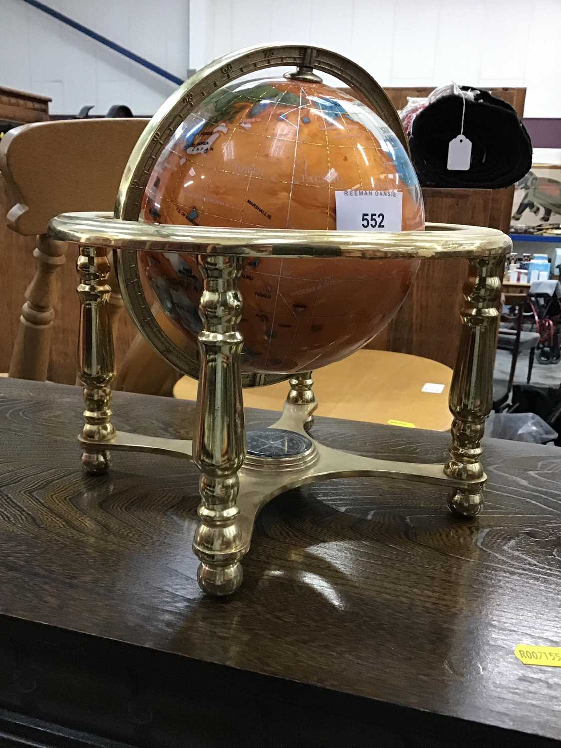 Lot 552 - A decorative stone finish globe on brass stand