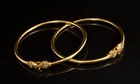 Lot 727 - Two Indian yellow metal bangles, each set with...