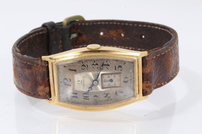 Lot 615 - 1920s mid-size Omega 18ct gold wristwatch with tonneau shape gold case, import hallmarks for Edinburgh 1928, on brown leather strap