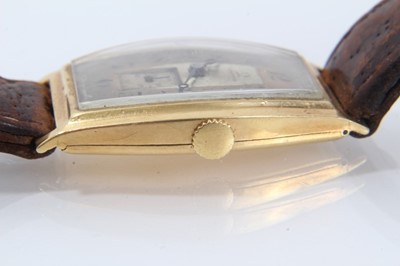 Lot 615 - 1920s mid-size Omega 18ct gold wristwatch with tonneau shape gold case, import hallmarks for Edinburgh 1928, on brown leather strap