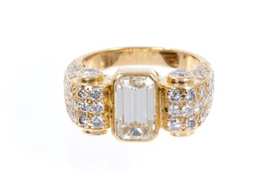 Lot 406 - Art Deco-style diamond dress ring, the principal emerald cut diamond measuring approximately 9.80mm x 5.50mm x 4.41mm, estimated to weigh approximately 2.51 carats, in a yellow gold rub-over settin...