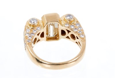 Lot 406 - Art Deco-style diamond dress ring, the principal emerald cut diamond measuring approximately 9.80mm x 5.50mm x 4.41mm, estimated to weigh approximately 2.51 carats, in a yellow gold rub-over settin...