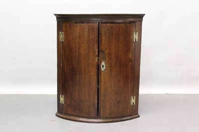 Lot 1232 - George III oak and fruitwood crossbanded bowfront hanging corner cupboard