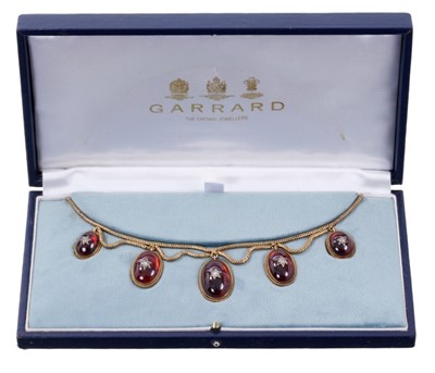 Lot 442 - Victorian gold and cabochon garnet fringe necklace with five graduated oval cabochon garnets with applied rose cut diamond stars, with rope twist borders and glazed locket compartment to the revers...