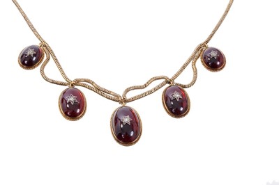 Lot 442 - Victorian gold and cabochon garnet fringe necklace with five graduated oval cabochon garnets with applied rose cut diamond stars, with rope twist borders and glazed locket compartment to the revers...