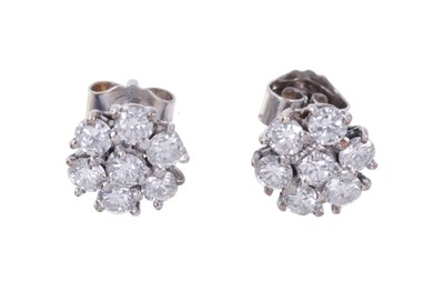 Lot 461 - Pair of diamond cluster earrings, each with a flower head cluster of seven round brilliant cut diamonds in white gold claw setting. Estimated total diamond weight approximately 1 carat.