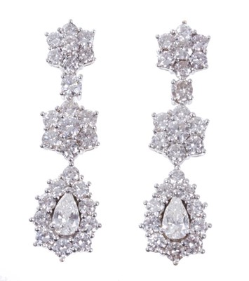 Lot 462 - Pair of diamond pendant earrings, each with a pear cut diamond drop surrounded by a border of brilliant cut diamonds, suspended from two further diamond clusters, estimated total diamond weight app...