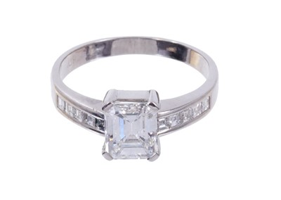 Lot 484 - Diamond single stone ring with a step cut diamond weighing approximately 1.23 carats in four claw setting with further step cut diamonds to the shoulders. Ring size L.