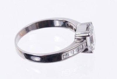 Lot 484 - Diamond single stone ring with a step cut diamond weighing approximately 1.23 carats in four claw setting with further step cut diamonds to the shoulders. Ring size L.