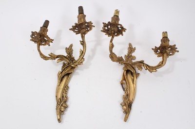 Lot 41 - Pair of Rococo style gilt metal wall sconces, each scrolling foliate bracket issuing twin arms, 31cm high