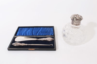 Lot 264 - George V silver handled shoe horn and button hook (Chester 1910) in a velvet lined fitted case, together with a cut glass scent bottle of spherical form with hob nail cut decoration