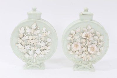 Lot 107 - Pair of 19th century continental porcelain moonflasks and covers, celadon glazed with encrusted floral decoration, 22cm height