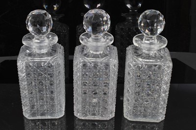 Lot 121 - Set of three Edwardian square cut glass decanters, 22.5cm height