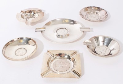 Lot 279 - Group of six Continental silver and white metal ashtrays and pin dishes, each one set centrally with a coin or medallion, all at 11.5oz (6)