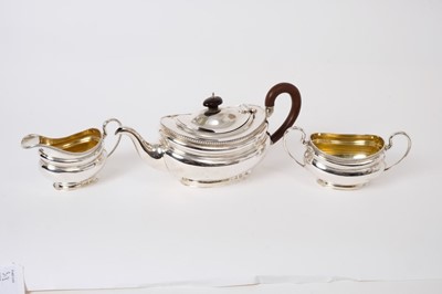 Lot 318 - Edwardian silver three piece tea set - comprising teapot of oval bellied form, gadrooned borders, fruitwood loop handle, hinged domed cover with turned wooden finial on an oval flared, matching sug...