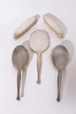 Lot 347 - George VI silver hand mirror with engine turned decoration (Birmingham 1937) maker Adie Brothers, together with four brushes (Birmingham 1936 / 37), mirror 29cm in length (5)