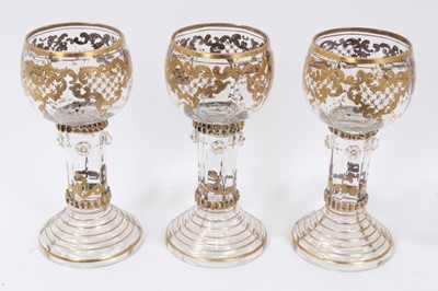 Lot 164 - Fine set of nine 19th century Bohemian glass goblets, the round bowls on hollow raspberry-prunted stems, on stepped feet, with raised gilt patterned decoration, 15.5cm height