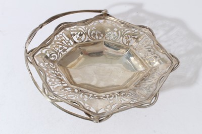 Lot 56 - Good quality Edwardian silver cake basket of oval form with faceted and pierced decoration and swing handle, raised on four claw and ball feet (London 1906)