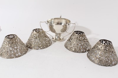 Lot 81 - Edwardian silver trophy cup / tyg of conventional form with three handles (Birmingham 1907), makers mark rubbed, together with a set of four silver pierced lamp shades by Gorham (5 items)