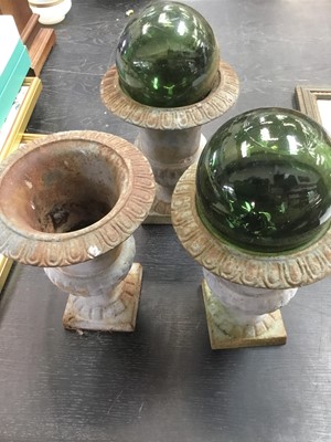 Lot 145 - Three cast iron garden urns and two glass witch balls