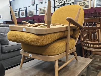 Lot 928 - Ercol stick back easy chair with matching stool with orange cushions