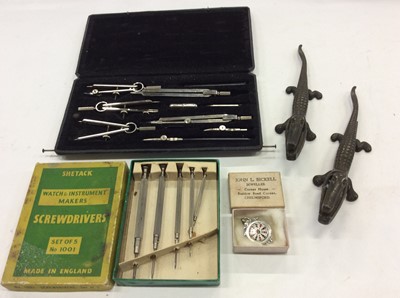 Lot 2069 - Set of drawing instruments, a set of watch makers screwdrivers, silver darts fob and pair of nut crackers in the form of Crocodiles