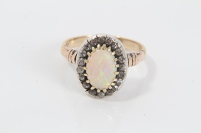 Lot 21 - Antique opal and diamond cluster ring with an oval cabochon opal surrounded by nineteen old cut diamonds in silver collet setting with pierced gold gallery on gold shank