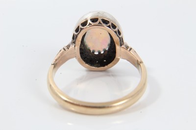 Lot 21 - Antique opal and diamond cluster ring with an oval cabochon opal surrounded by nineteen old cut diamonds in silver collet setting with pierced gold gallery on gold shank