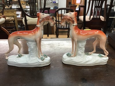 Lot 88 - Pair Victorian Staffordshire figures of greyhounds, both with rabbits in their mouths, on oval gilt-lined bases