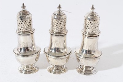 Lot 77 - Trio of George V silver pepperettes in the Georgian style with engraved crests (London 1915), all at 7ozs