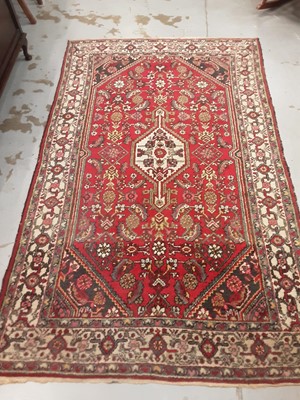 Lot 1051 - Eastern rug with geometric decoration on red, blue and cream ground, 215cm x 128cm