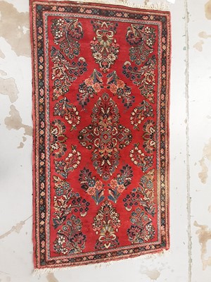 Lot 1054 - Eastern rug on red ground, 120cm x 64cm