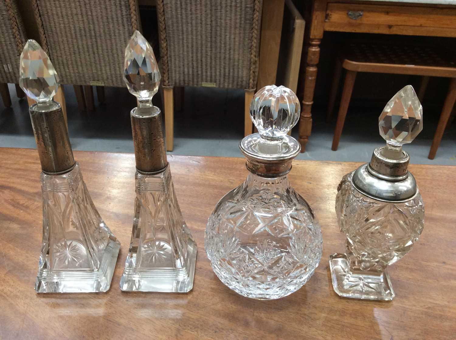 Lot 702 - Four silver collared cut glass bottles