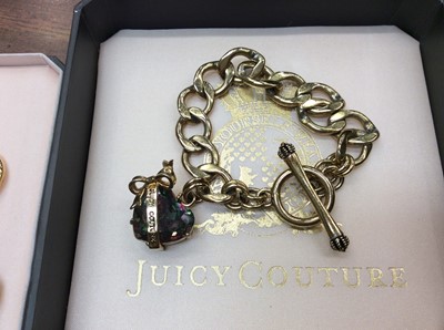Lot 706 - Juicy Couture gilt metal necklace and matching bracelet with bow and heart decoration and one other bracelet with heart charm