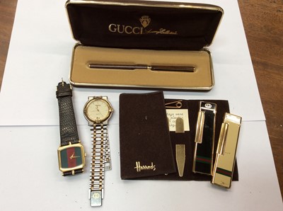 Lot 710 - Vintage Gucci pen in box, two Gucci wristwatches, two Gucci lighters and a Harrods brass collar stays set in pouch