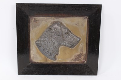 Lot 325 - Early 20th century pewter relief plaque of a terrier, mounted in ebonised oak frame