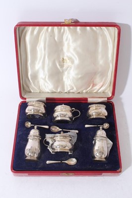Lot 223 - George VI six piece silver cruet set comprising two mustard pots of baluster form with decorative borders, hinged covers and blue glass liners, together with two matching pepperettes