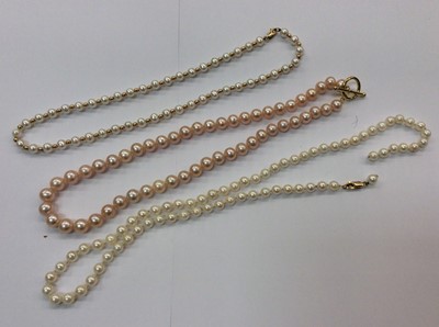 Lot 651 - Two cultured pearl necklaces with 9ct gold clasps and pink cultured pearl necklace with gilt metal T bar clasp (3)