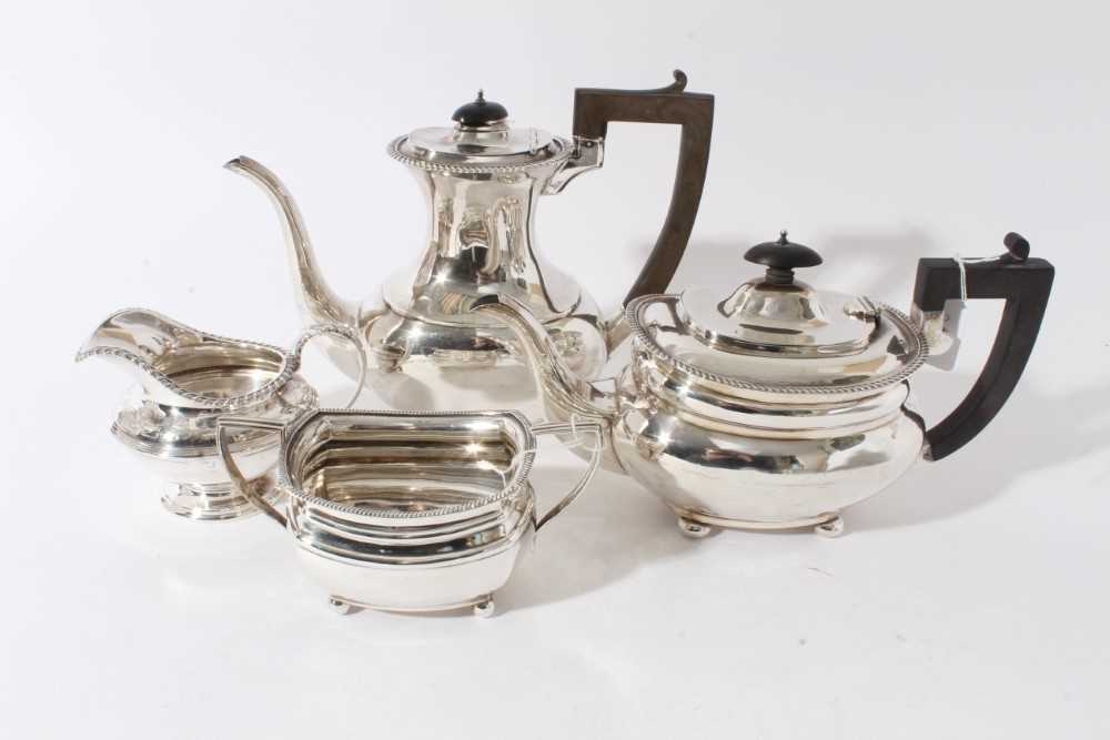 Lot 29 - George V silver and silver plated composite four piece tea and coffee set- comprising teapot of compressed baluster form, hinged domed cover, angular ebony handle, raised on four ball feet