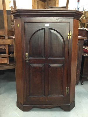 Lot 884 - George III oak corner cupboard with ached panelled door enclosing three shaped shelves on bracket feet