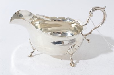 Lot 32 - Pair of Edwardian silver sauce boats of conventional form with scroll handles, each raised on three hoof feet, (London 1901) makers mark rubbed, all at approximately 10.5oz, 16cm from handle to spout.