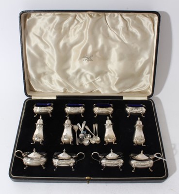 Lot 240 - Extensive George V silver cruet set comprising four silver mustard pots of bulbous rectangular form with hinged covers and blue glass liners