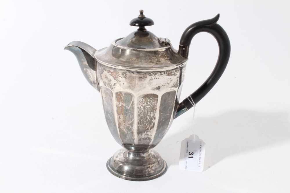 Lot 31 - George V silver hot water jug of tapered form with faceted decoration, ebony finial and loop handle, raised on circular foot, (Sheffield 1931) maker Viners Ltd