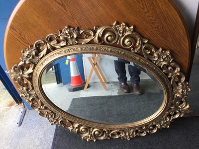 Lot 1072 - Ornate gilt framed oval wall mirror together with a narrow dressing mirror with arched top (2 mirrors)